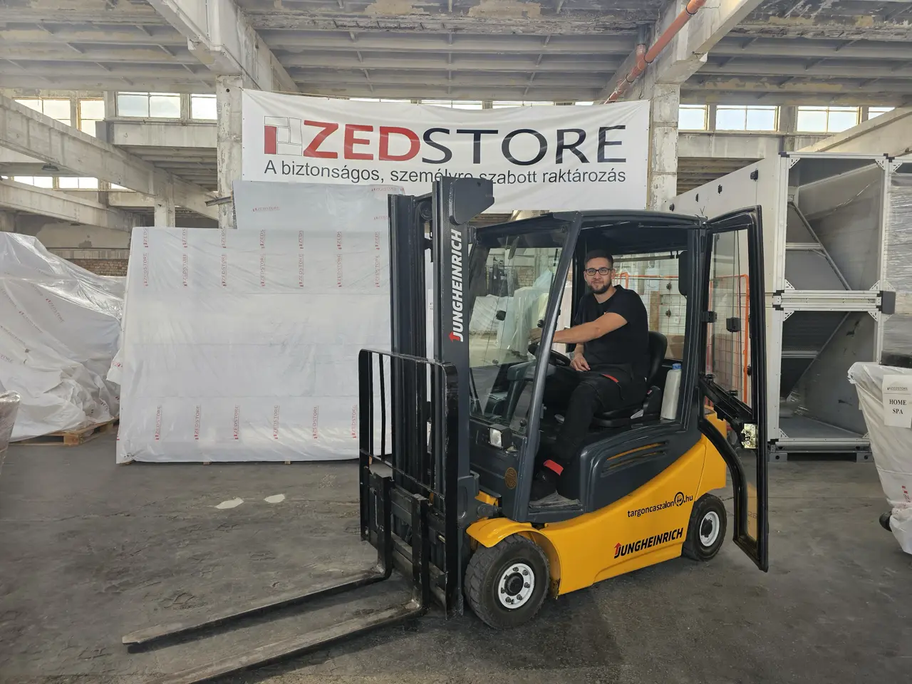 ZedStore munkatárs targoncával a fóliázott, tárolt áruk között a budapesti raktárban